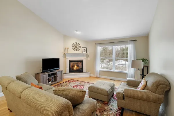a living room with furniture a flat screen tv and a window