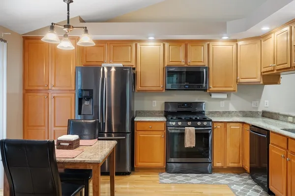 a kitchen with stainless steel appliances granite countertop a stove refrigerator sink and microwave