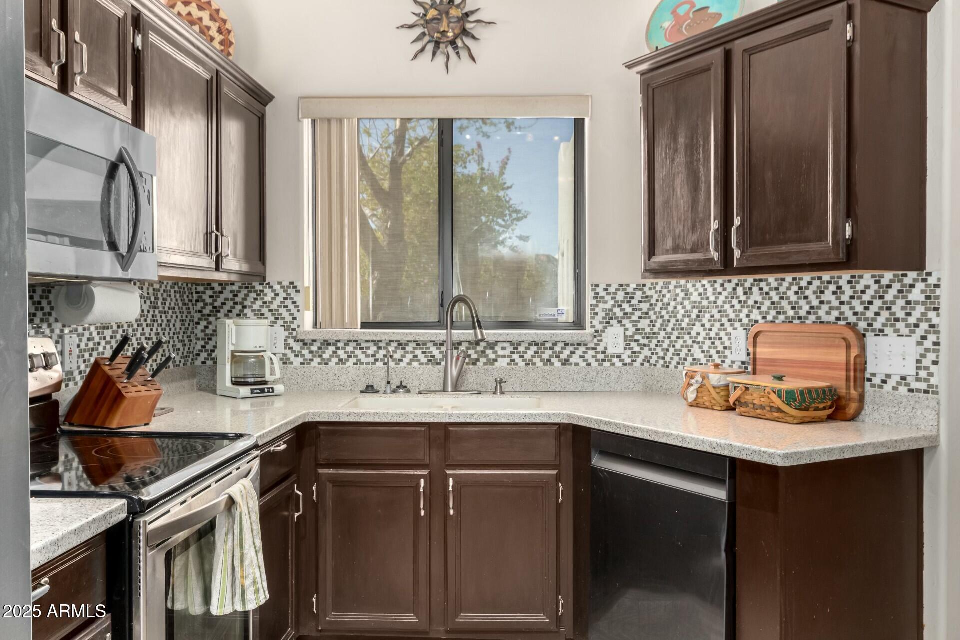 5445 East McKellips Road, Unit 54 Mesa, AZ 85215 - Photo 4 of 26 a kitchen with a sink cabinets and a window