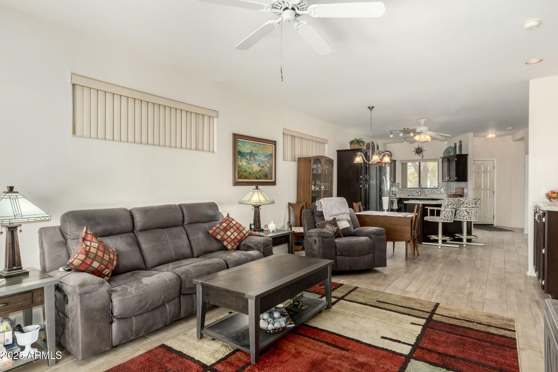 5445 East McKellips Road, Unit 54 Mesa, AZ 85215 - Photo 7 of 26 a living room with furniture a rug and a chandelier