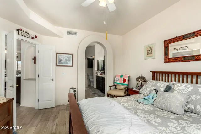 a bedroom with bed and wooden floor