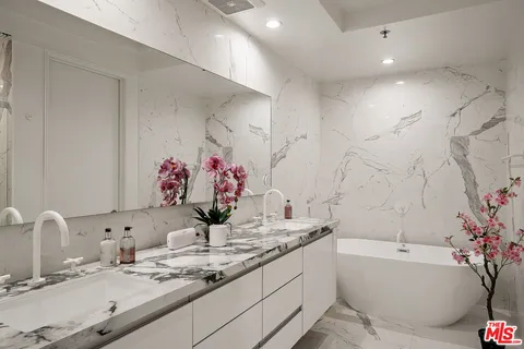 a bathroom with a granite countertop sink mirror and a bathtub