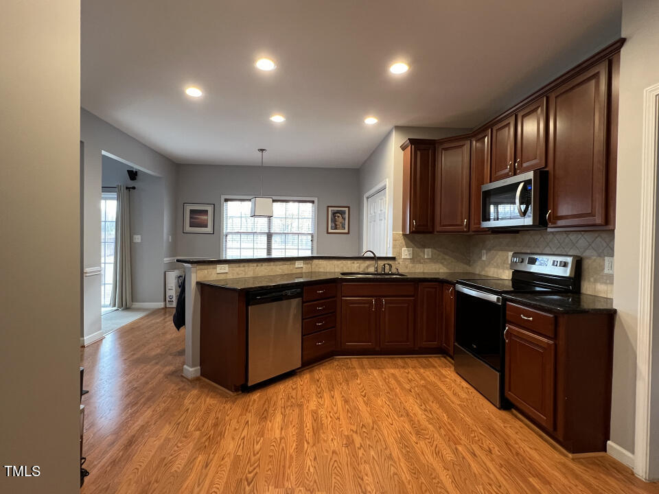 613 Seastone Street Raleigh, NC 27603 - Photo 11 of 13 a kitchen with stainless steel appliances granite countertop a stove a sink and a microwave