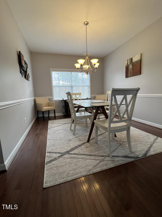 613 Seastone Street Raleigh, NC 27603 - Photo 5 of 13 a view of a dining room with furniture a chandelier and wooden floor