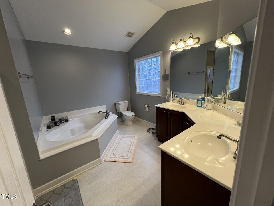 613 Seastone Street Raleigh, NC 27603 - Photo 6 of 13 a en suite bathroom with a sink double vanity granite and a mirror