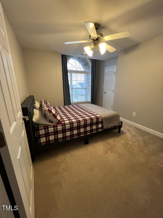 613 Seastone Street Raleigh, NC 27603 - Photo 8 of 13 a bedroom with a bed and a chandelier