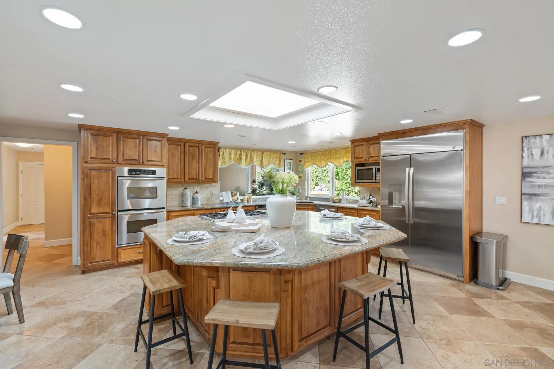 13678 Orchard Gate Road Poway, CA 92064 - Photo 11 of 29 a kitchen with stainless steel appliances granite countertop a table chairs and a refrigerator