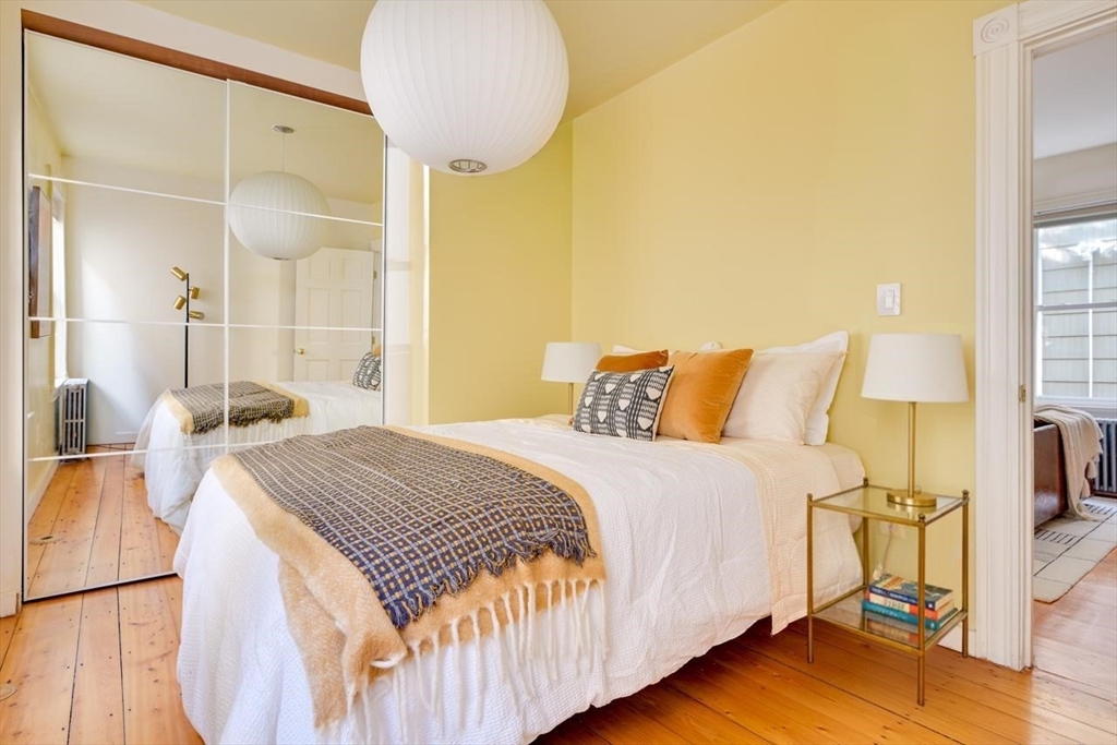 33 Line Street, Unit 1 Cambridge, MA 02138 - Photo 13 of 22 a bedroom with a bed and a chandelier