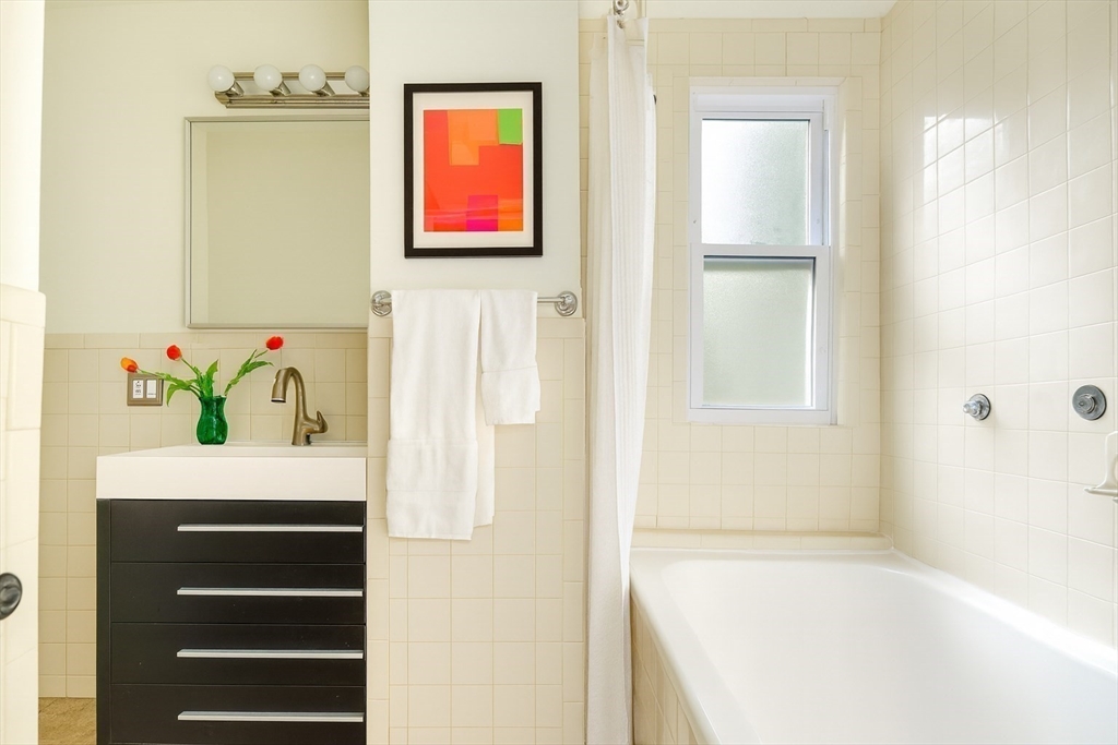 33 Line Street, Unit 1 Cambridge, MA 02138 - Photo 17 of 22 a bathroom with a bathtub sink and mirror