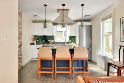 a kitchen with granite countertop stainless steel appliances a sink stove and cabinets