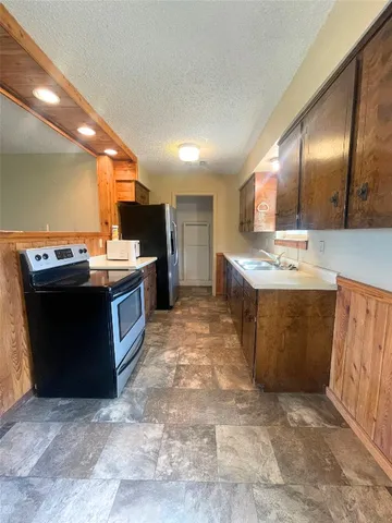 a kitchen with stainless steel appliances granite countertop a stove a sink dishwasher and a refrigerator