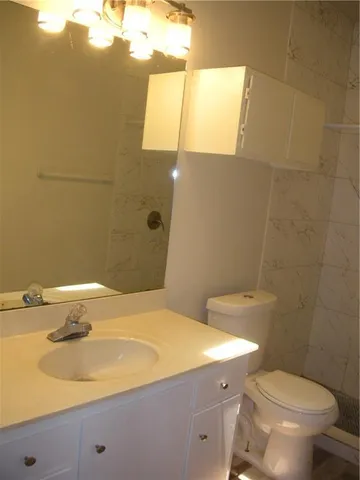 a bathroom with a sink a toilet and mirror