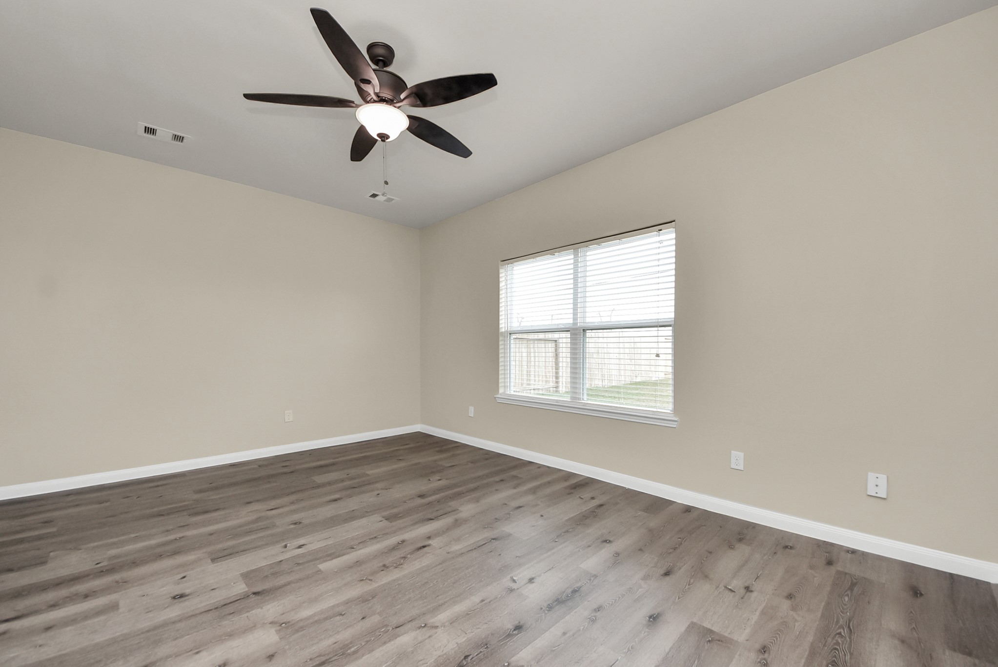 1855 Garnet Breeze Drive Rosharon, TX 77583 - Photo 14 of 40 an empty room with wooden floor fan and windows