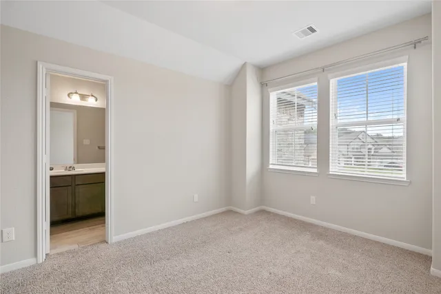 an empty room with windows and cabinet