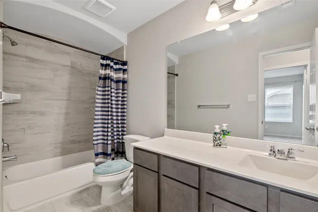 a bathroom with a sink a toilet a mirror a bathtub and shower