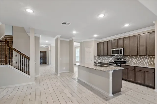 a kitchen with stainless steel appliances granite countertop a sink stove and refrigerator