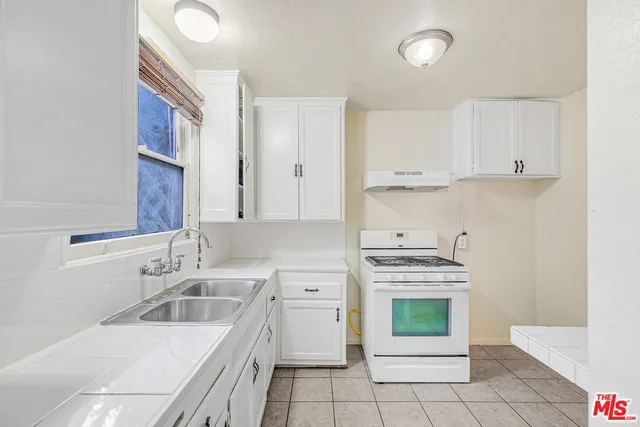 a kitchen with a stove sink and cabinets