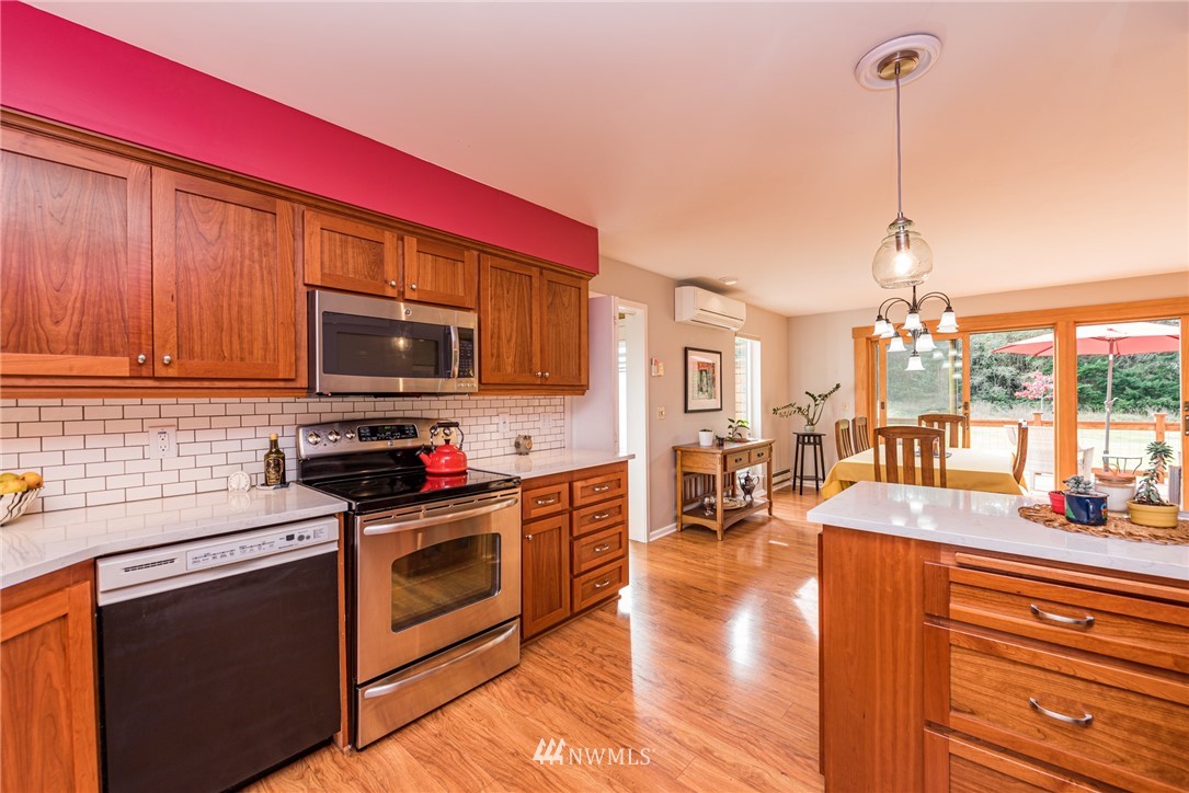 481 Holgerson Road Sequim, WA 98382 - Photo 17 of 40 a kitchen with stainless steel appliances granite countertop a stove top oven a sink dishwasher and a microwave with wooden floor