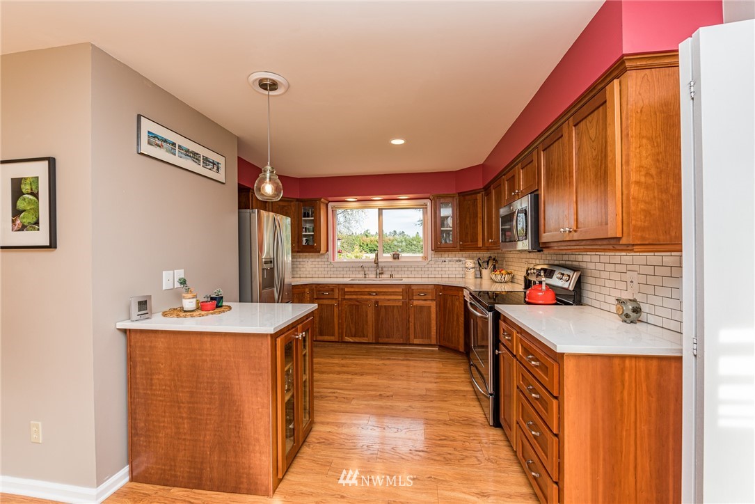481 Holgerson Road Sequim, WA 98382 - Photo 18 of 40 a kitchen with a sink stove and cabinets