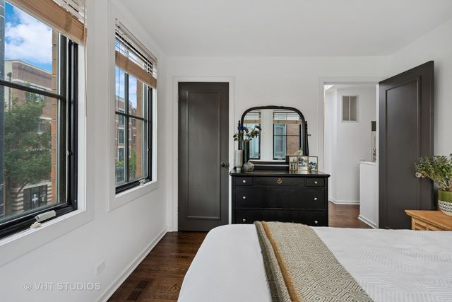 a bedroom with a bed and a dresser next to a window