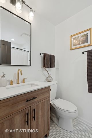 a bathroom with a granite countertop toilet sink a mirror and vanity
