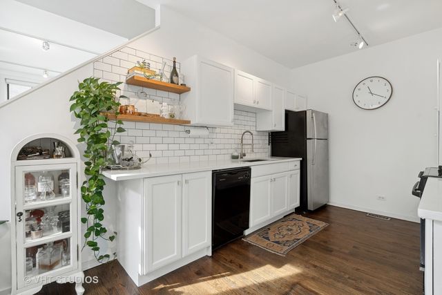 a kitchen with a sink cabinets and wooden floor