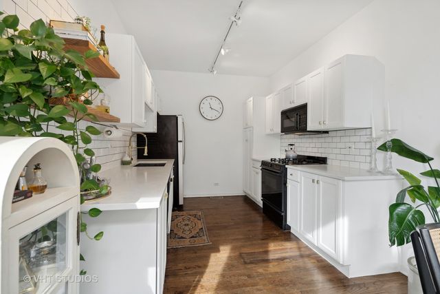 a kitchen with stainless steel appliances a stove a refrigerator a sink a stove with white cabinets