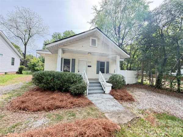 a front view of a house with a yard and potted plants