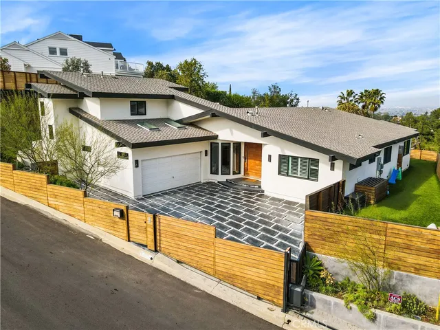 a front view of a house with a garden