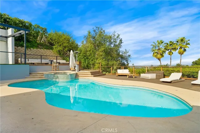a porch with a table and chairs under an umbrella