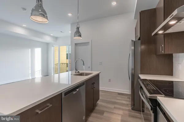 a kitchen with granite countertop a sink stainless steel appliances and cabinets