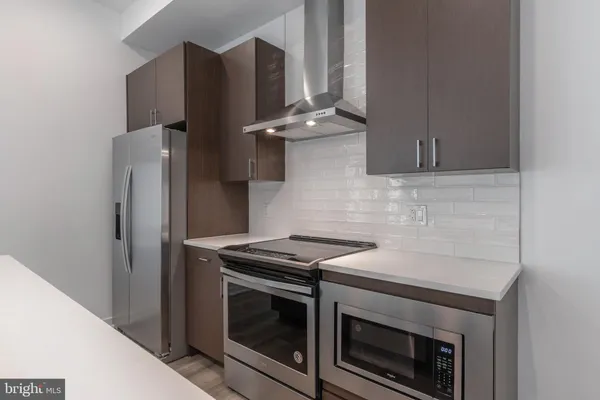 a kitchen with stainless steel appliances wooden cabinets sink and stove