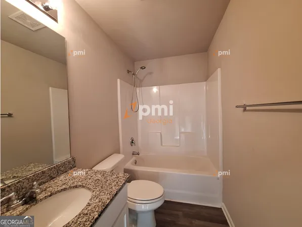 a bathroom with a granite countertop sink a large mirror and a shower