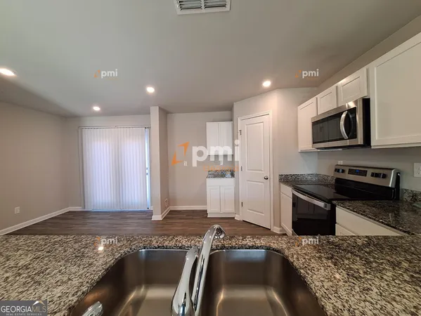 a kitchen with granite countertop kitchen island stainless steel appliances a refrigerator and a stove top oven