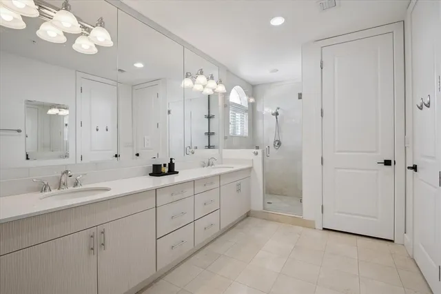 a spacious bathroom with a double vanity sink mirror and shower