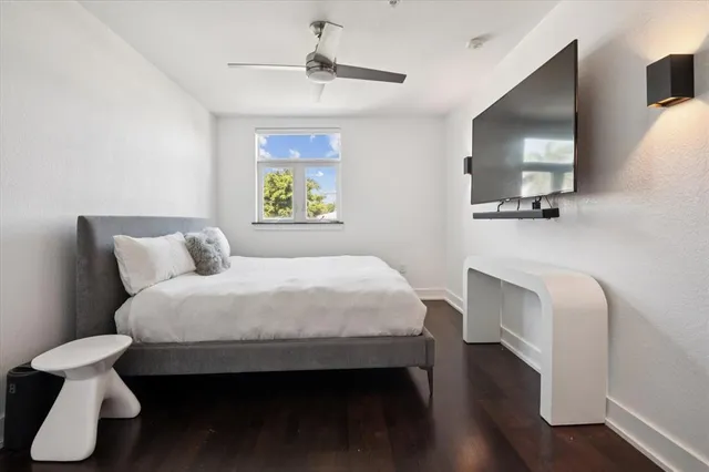 a bedroom with a bed a table and painting on the wall