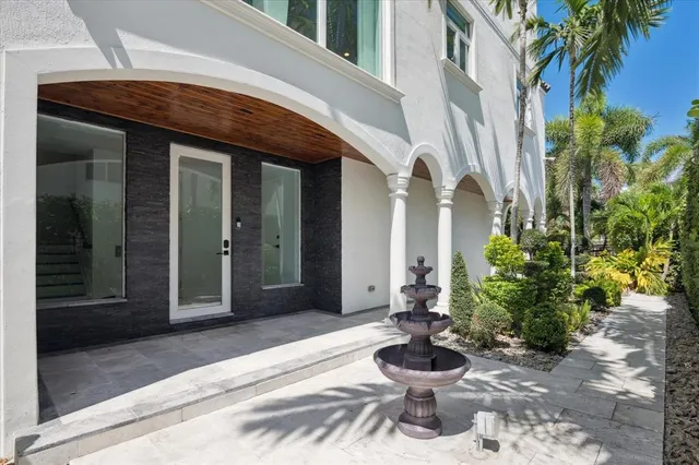 a view of a porch with a potted plant and floor to ceiling windows