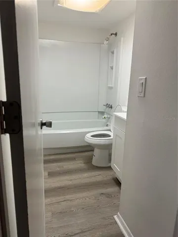 a view of empty room with wooden floor and cabinet