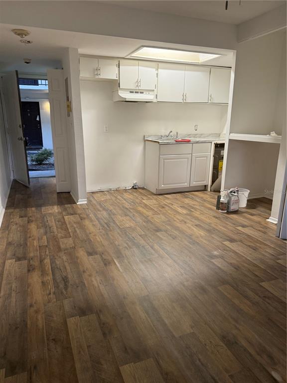 1264 East 113th Avenue, Unit J102 Tampa, FL 33612 - Photo 6 of 9 a view of empty room with wooden floor and cabinet