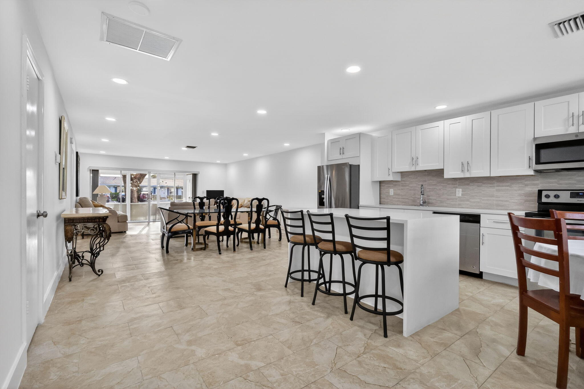5093 Privet Place, Unit A1 Delray Beach, FL 33484 - Photo 3 of 54 a group of chairs sitting in kitchen and kitchen island