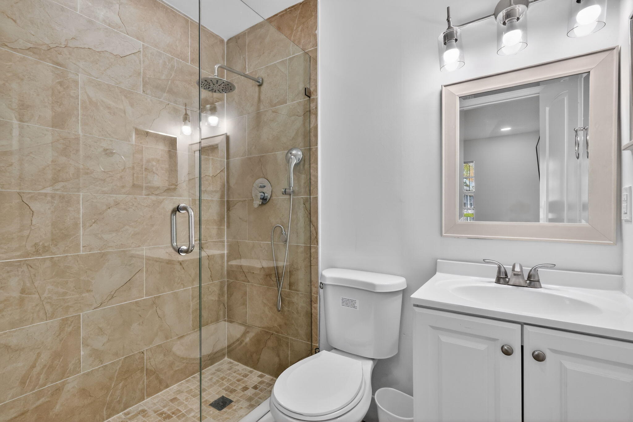 5093 Privet Place, Unit A1 Delray Beach, FL 33484 - Photo 35 of 54 a bathroom with a shower sink vanity and toilet