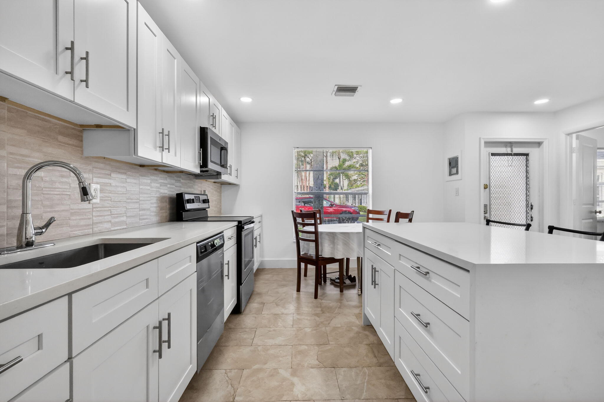 5093 Privet Place, Unit A1 Delray Beach, FL 33484 - Photo 9 of 54 a kitchen with cabinets appliances and a sink
