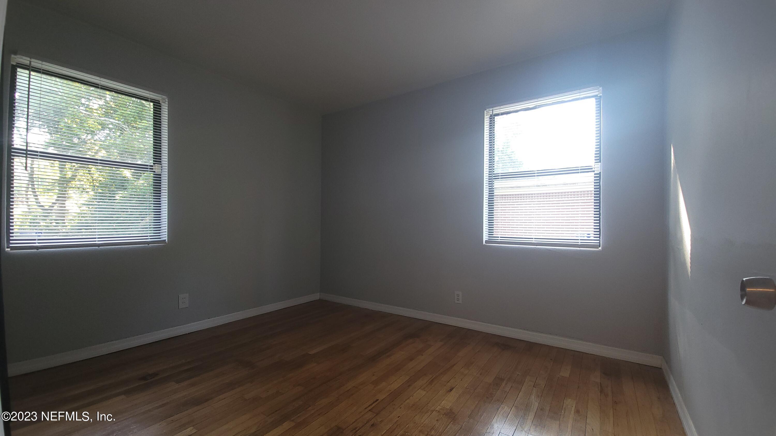 5721 Bree Road Jacksonville, FL 32209 - Photo 14 of 15 an empty room with wooden floor and windows