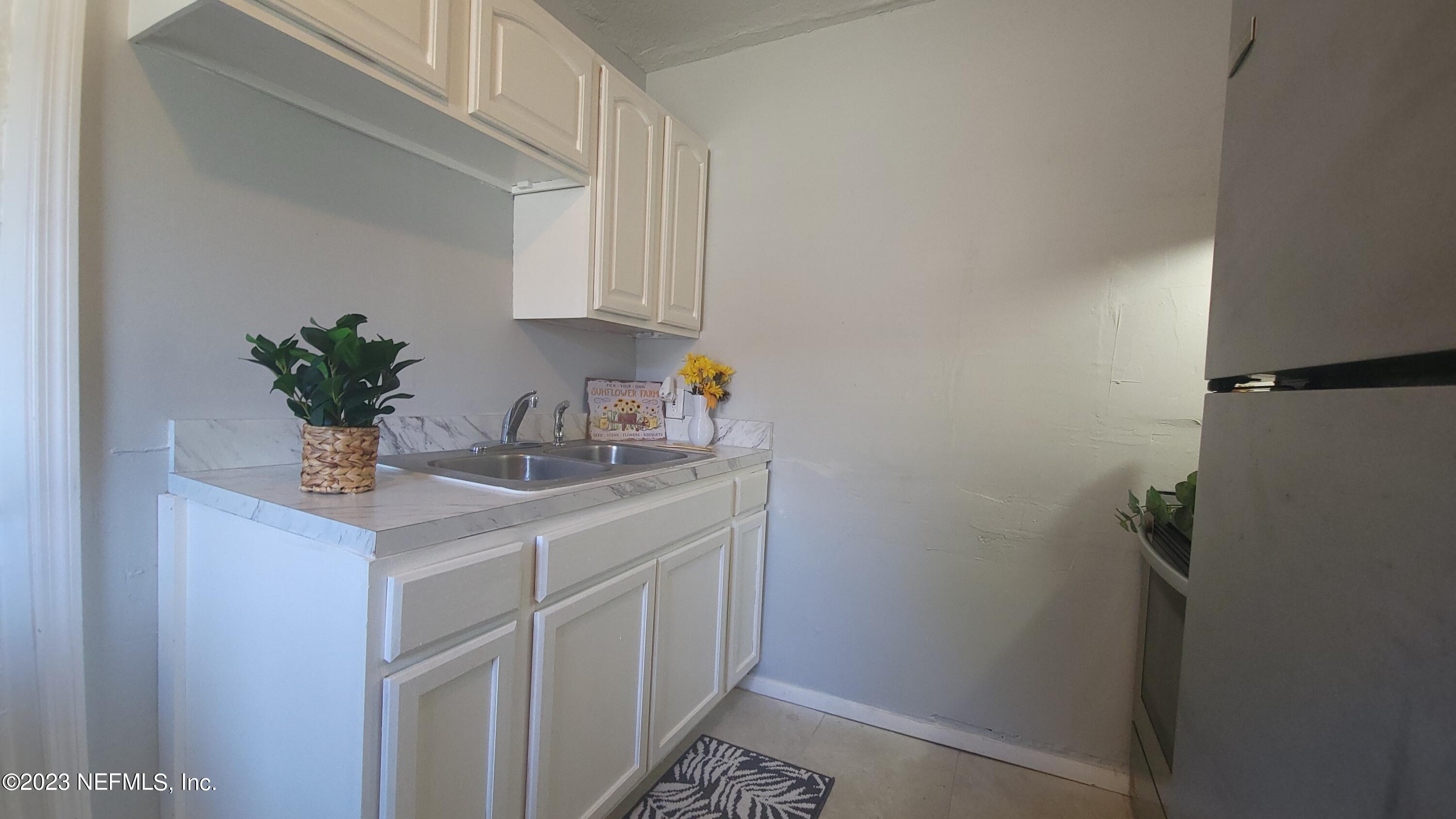 5721 Bree Road Jacksonville, FL 32209 - Photo 5 of 15 a bathroom with a sink a mirror and cabinets