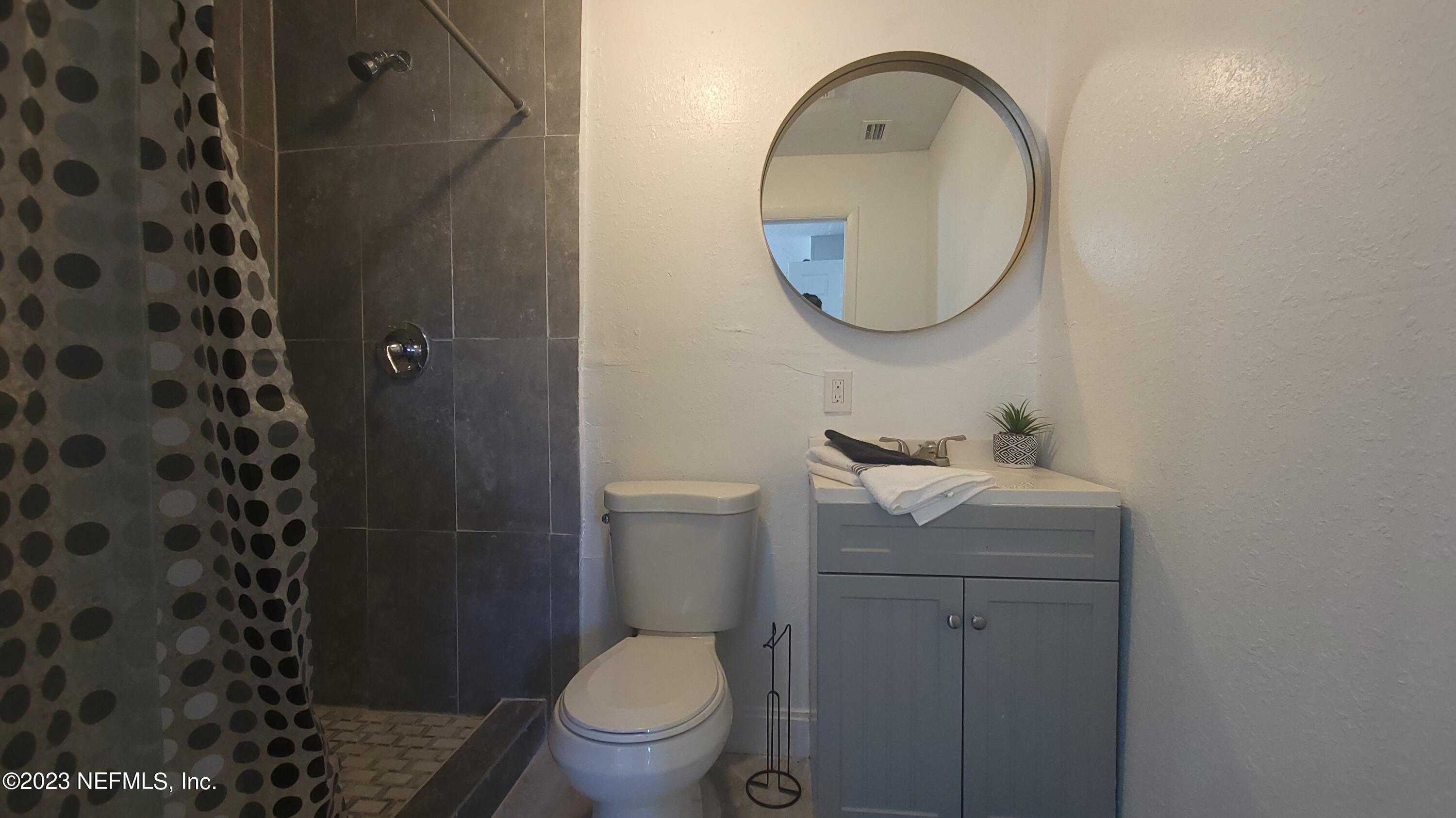 5721 Bree Road Jacksonville, FL 32209 - Photo 9 of 15 a bathroom with a toilet a sink and a mirror