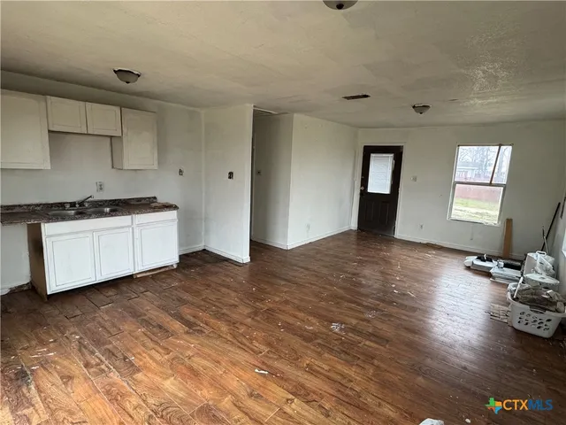 a kitchen with stainless steel appliances granite countertop a sink stove and wooden floor