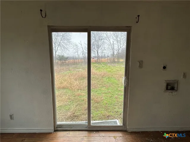 a kitchen with wooden floor and white stainless steel appliances