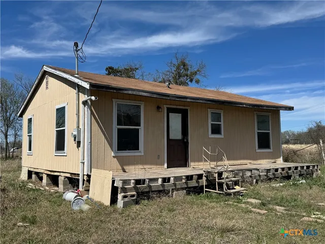 a view of house with backyard space and sitting area