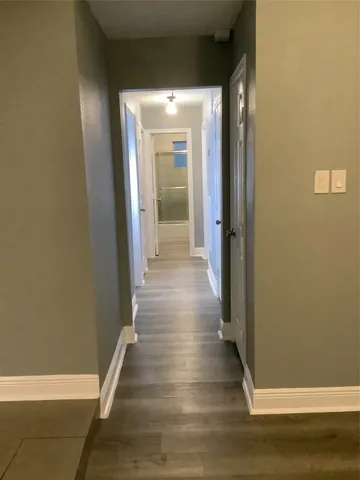 a view of a hallway with wooden floor