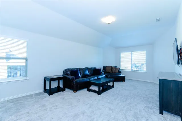 a living room with furniture wall paintings and a window